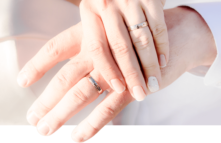 結婚指輪をはめて手をつなぐ男女イメージ画像
